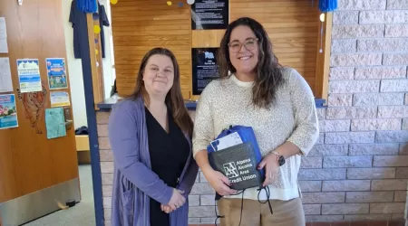 AAACU Team members pose with bags of trash they cleaned up in the community.